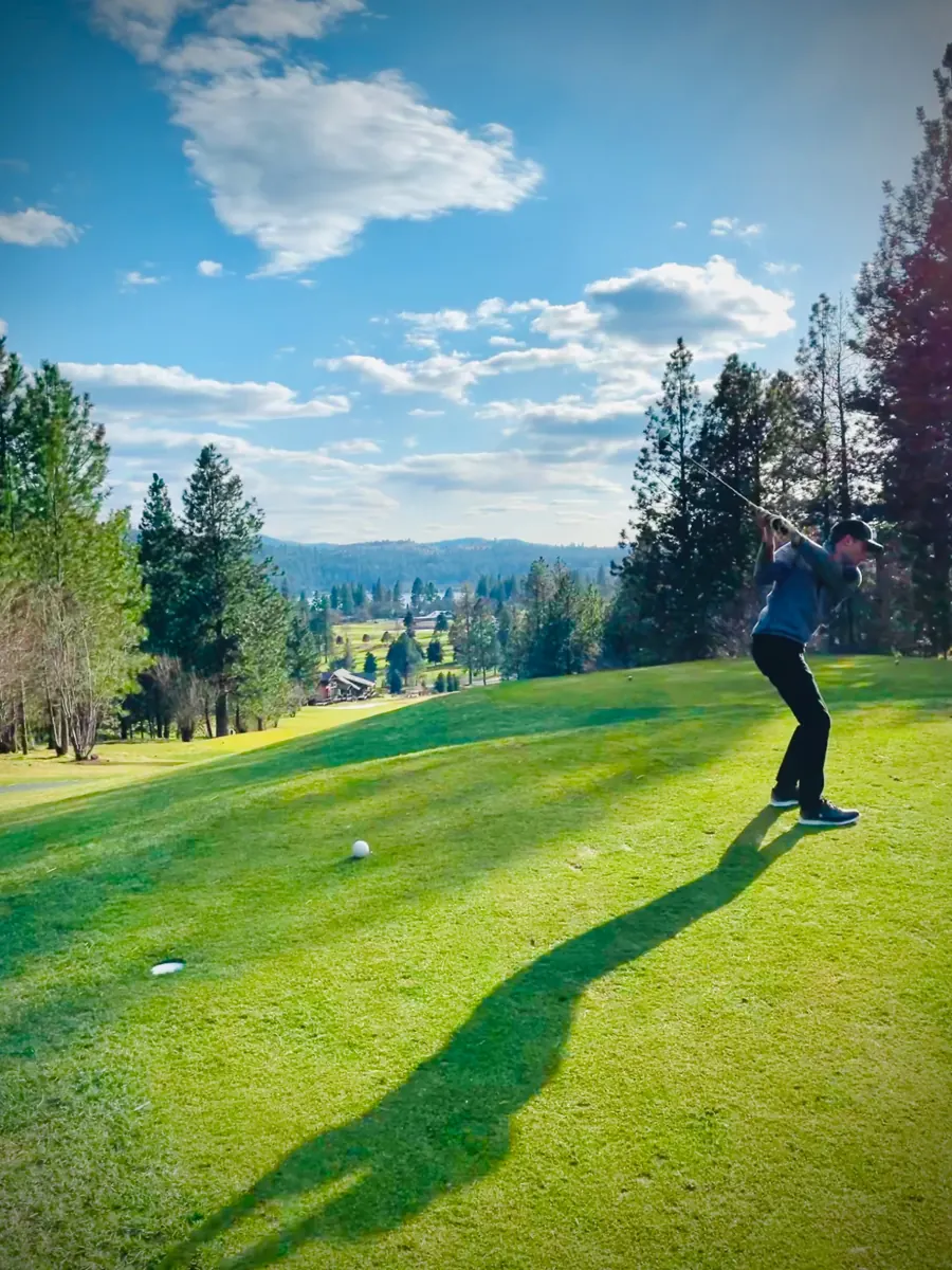Golfer teeing off on the 18th hole at Meadowwood in Liberty Lake, Washington